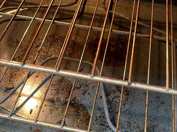 Before apartment cleaning - dirty oven interior in a San Diego apartment
